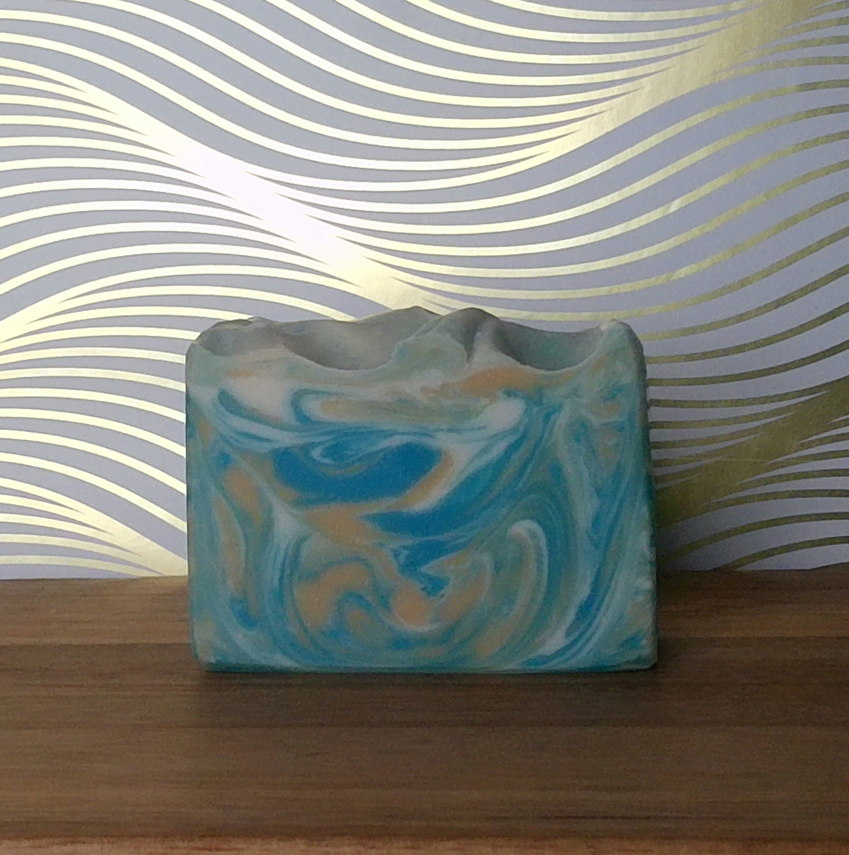 Dream handcrafted soap bar on a wooden soap dish in a bright bathroom setting.